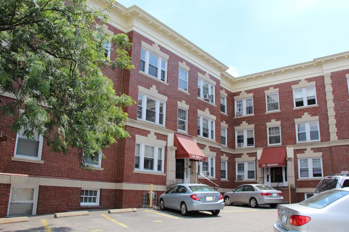 Three-story brick Bromley building with red entry awnings