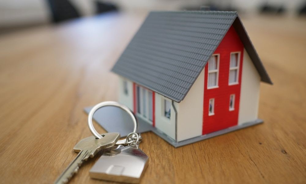 What Is Property Management article main image. It's a photo of a model house on a table with a set of keys.